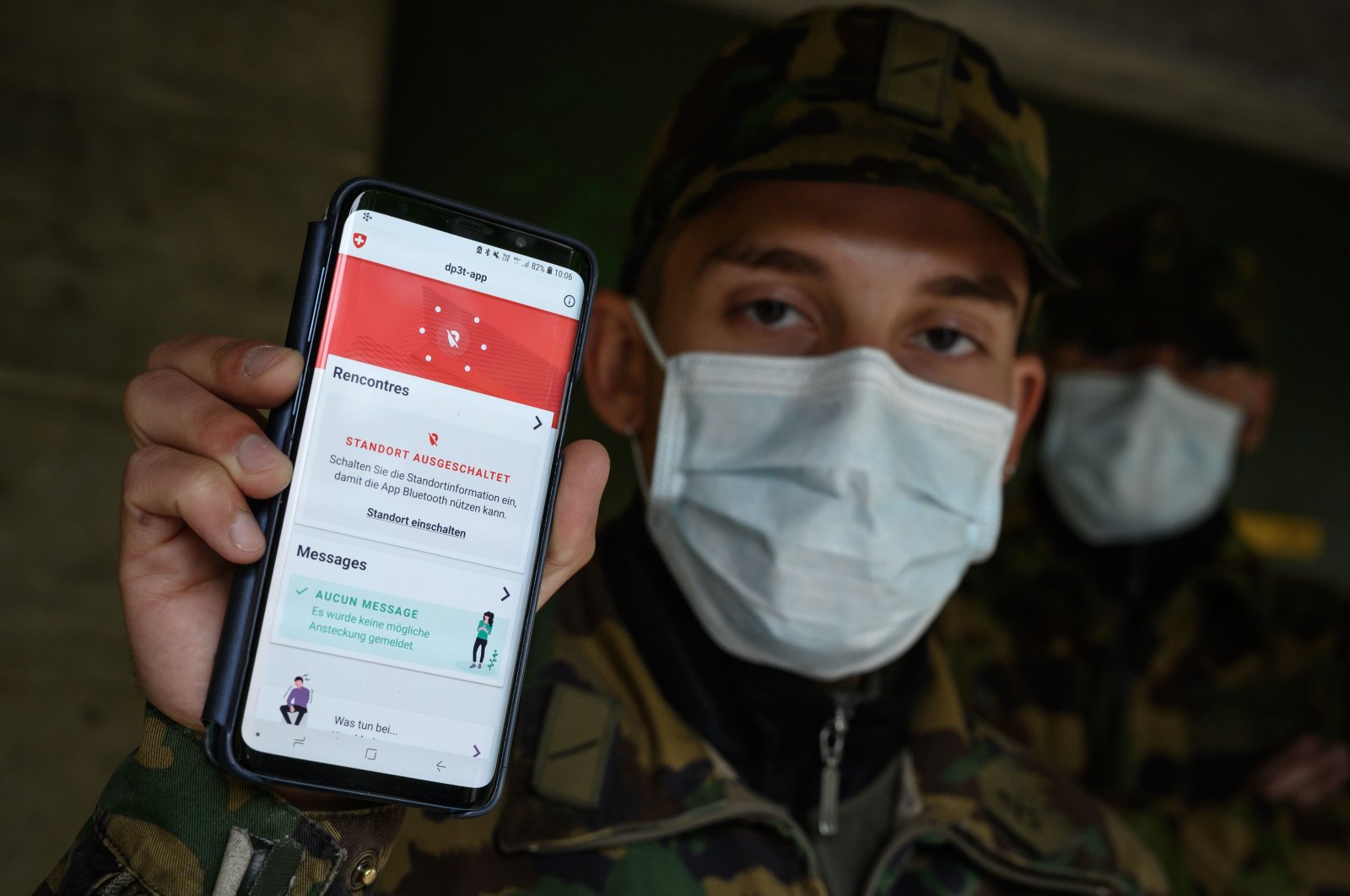 A Swiss soldier wearing a protective face mask poses with his smartphone at the Swiss army barracks of Chamblon on April 30, 2020. 