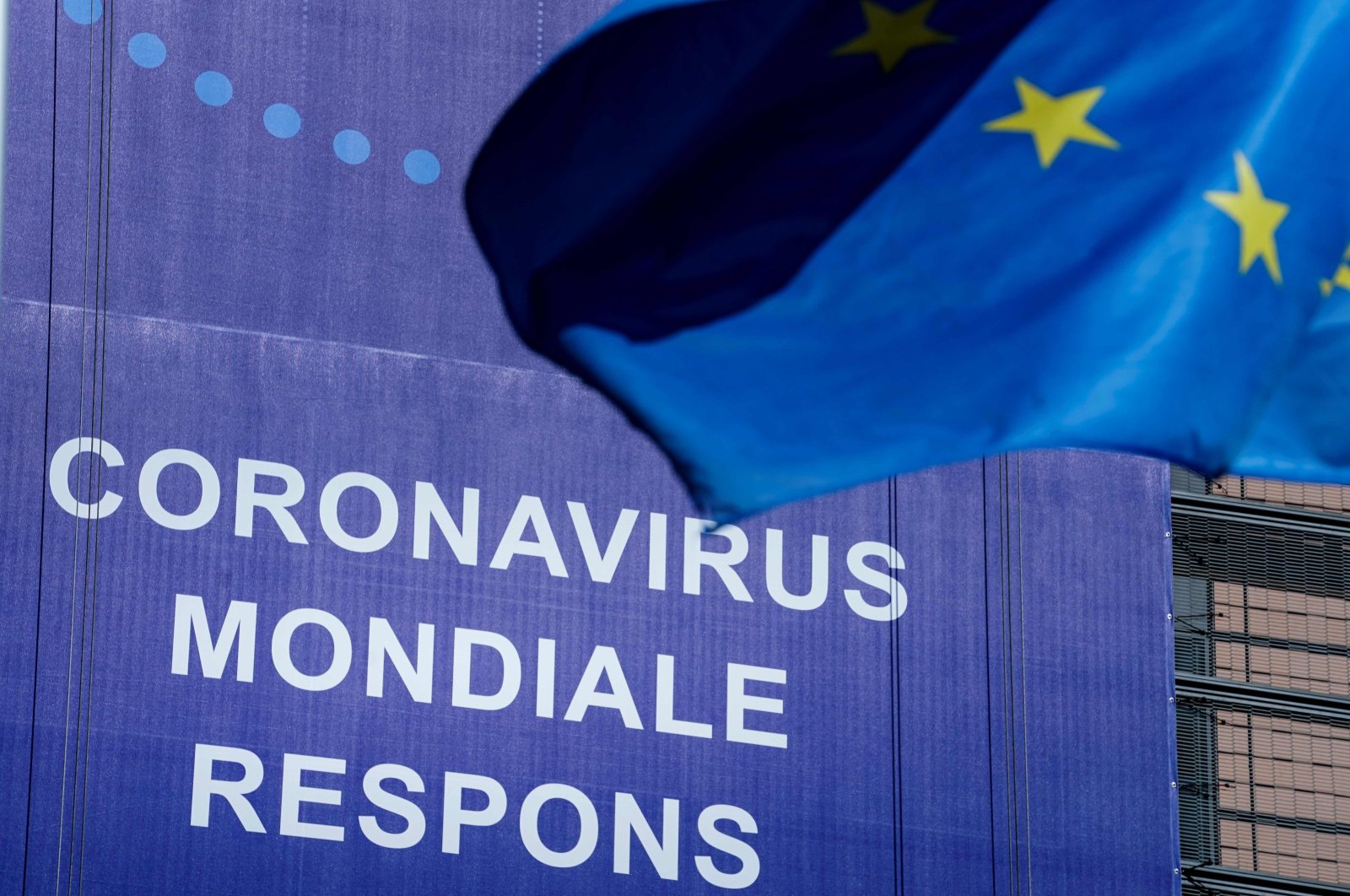 An European Union (EU) flag flutters in front of a newly hung banner that reads "Coronavirus Global Response" in front of The EU Commission building in Brussels, on May 6, 2020. (AFP Photo)