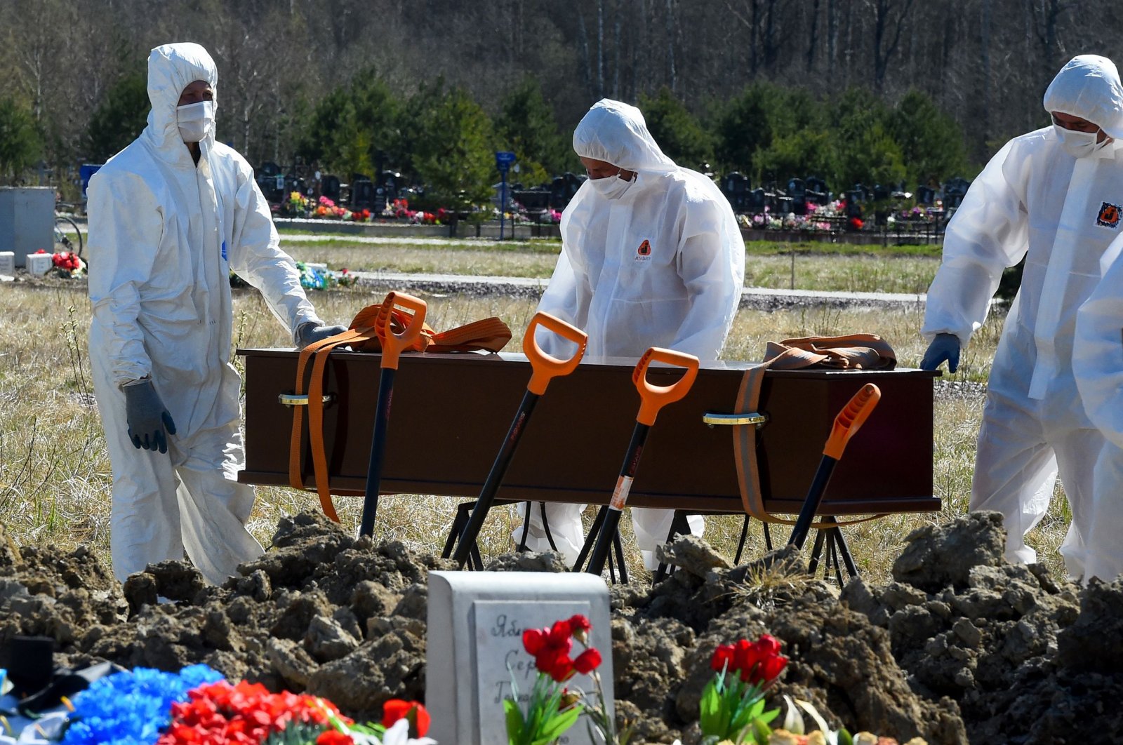 Cemetery workers wearing protective gear bury a coronavirus victim at a cemetery on the outskirts of Saint Petersburg, Russia, May 6, 2020. (AFP Photo)