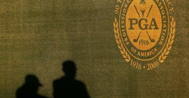 Two shadows of grounds crew are seen on the wall near the PGA logo during practice for the 2006 PGA Championship at Medinah Country Club in Medinah, U.S., Aug. 16, 2006. (AFP Photo)