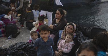 Refugees and migrants wait for buses after their arrival at the port of Elefsina, near Athens, Greece, Oct. 22, 2019. (AP Photo)