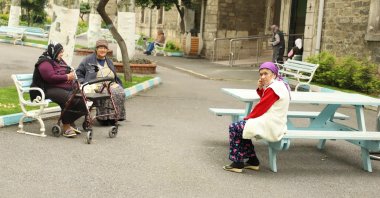 Residents of Darülaceze nursing home sit on benches in the courtyard, in Istanbul, May 10, 2020. (AA Photo) 