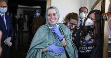 Silvia Romano, wearing a green tunic, reacts upon her arrival at the Ciampino airport, Rome, Italy, May 10, 2020. (EPA Photo)