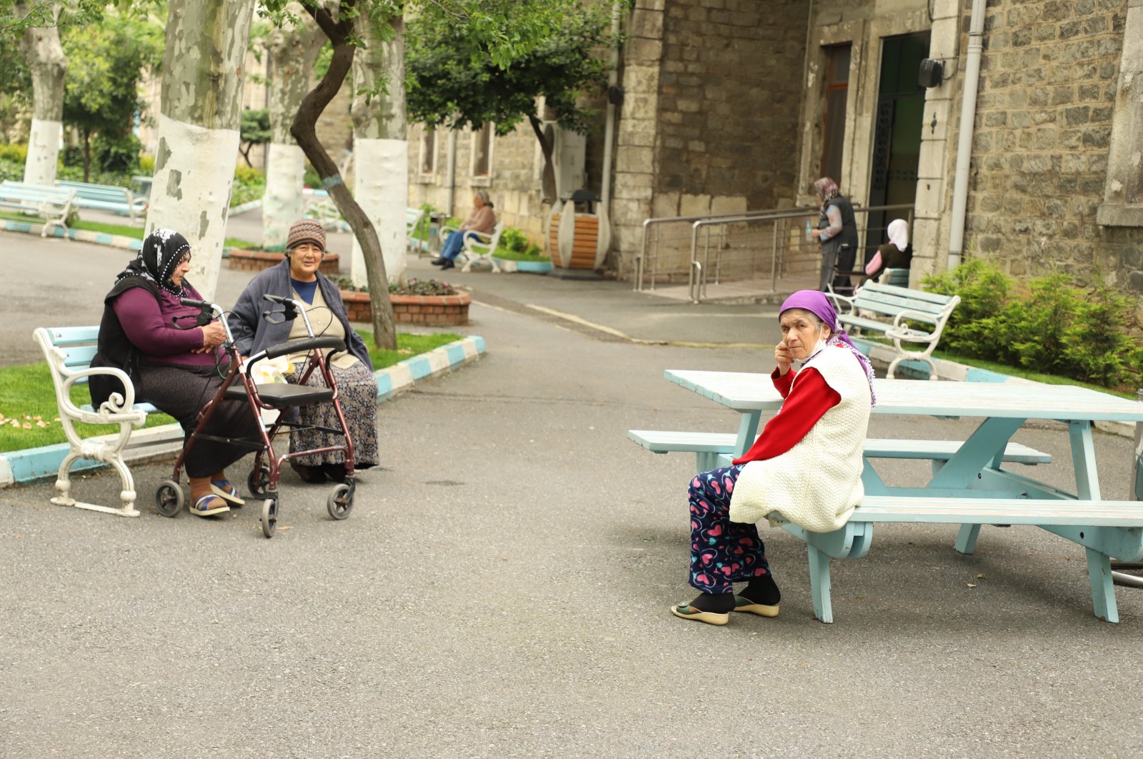 Residents of Darülaceze nursing home sit on benches in the courtyard, in Istanbul, May 10, 2020. (AA Photo) 