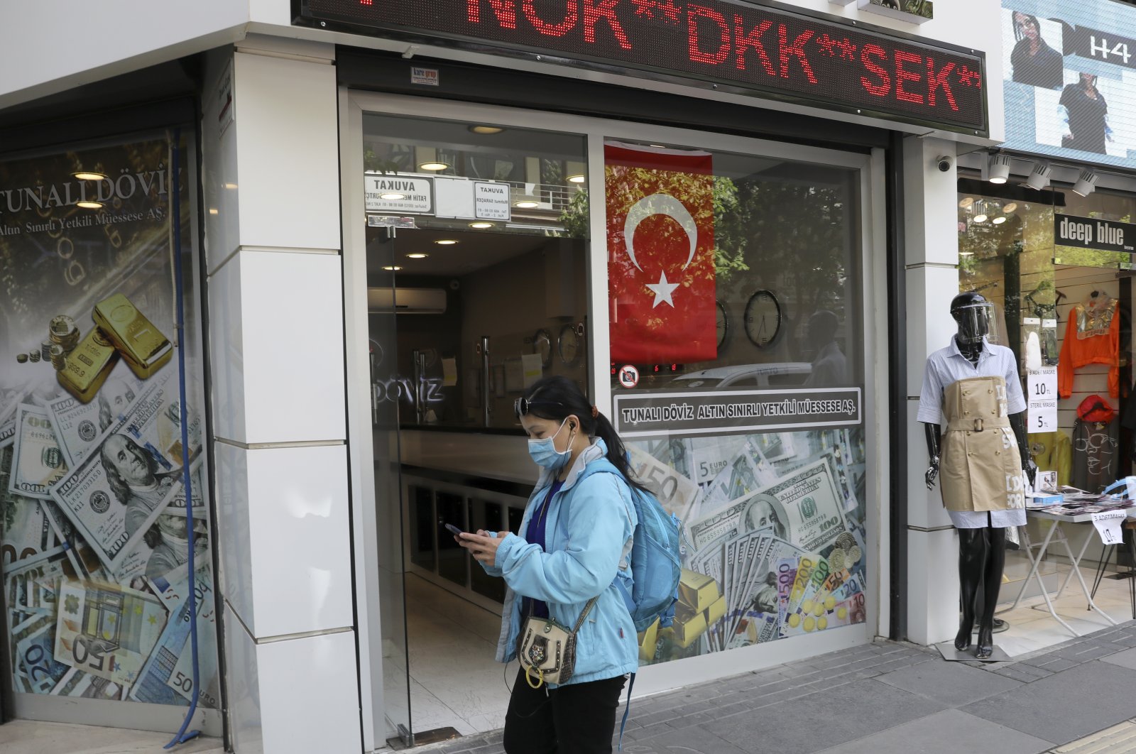 A foreigner wearing a face mask for protection against the coronavirus leaves a currency exchange office in Ankara, Turkey, Friday, May 8, 2020. (AP Photo)
