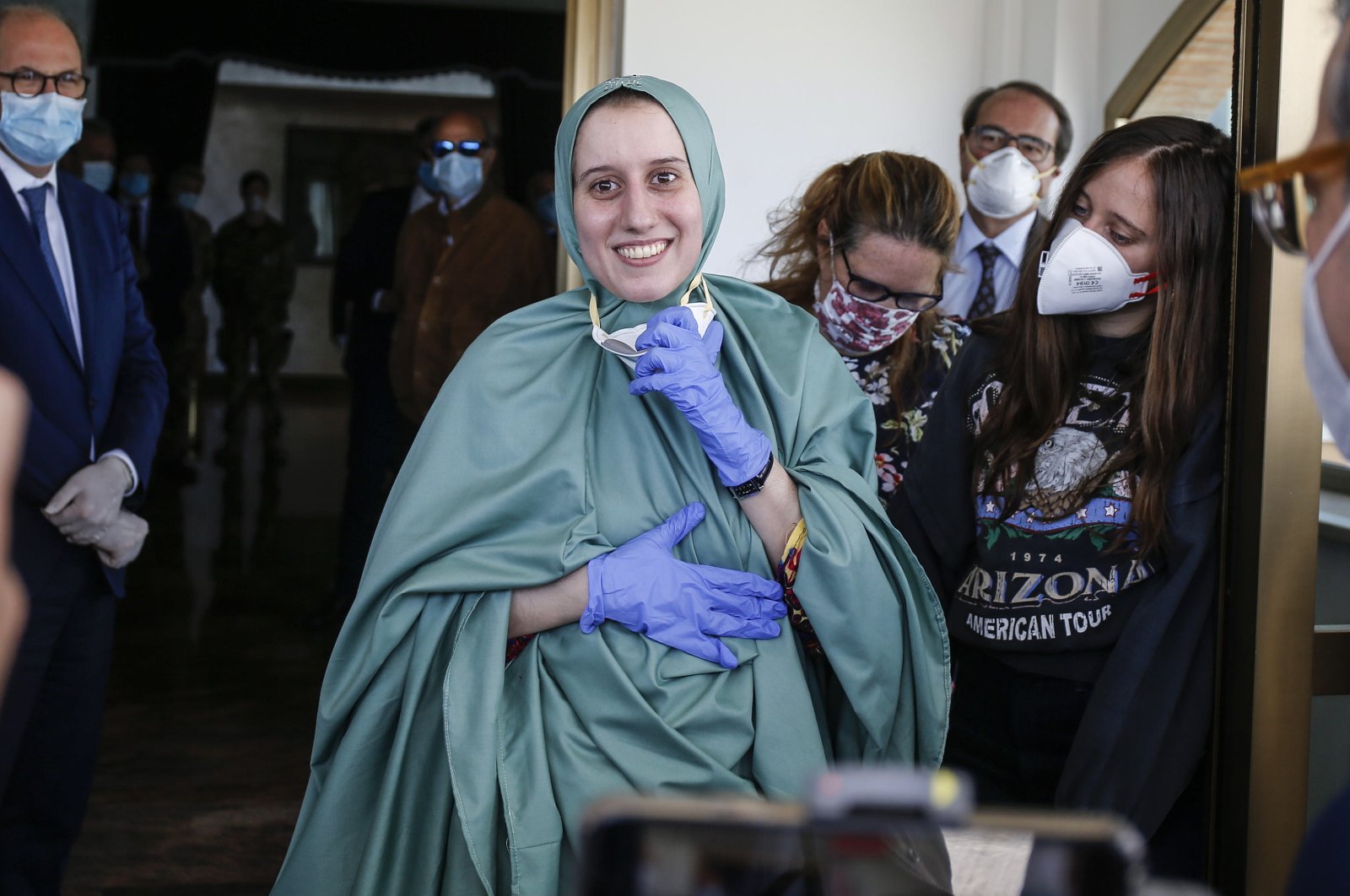 Silvia Romano, wearing a green tunic, reacts upon her arrival at the Ciampino airport, Rome, Italy, May 10, 2020. (EPA Photo)