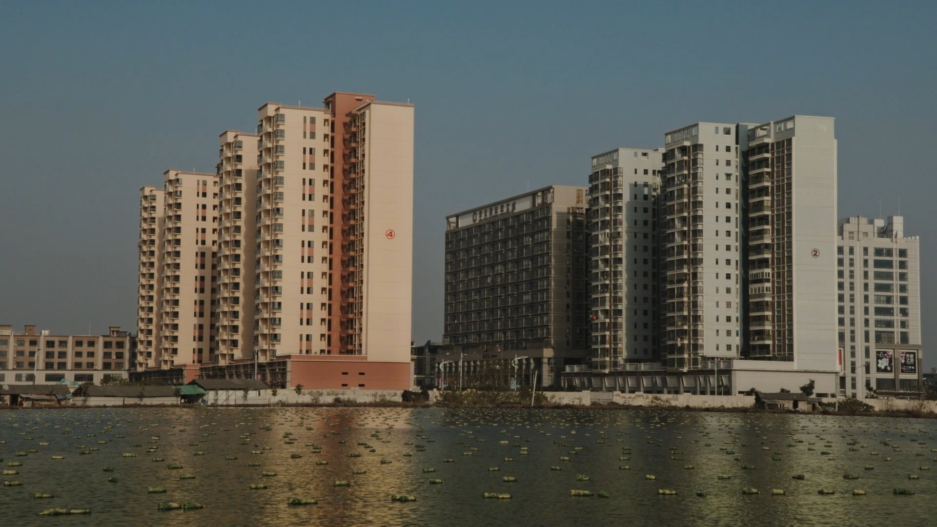 In the opening scene of 'NoNoseKnows,' tall buildings shadow irregular housing along a waterway. (Photo courtesy of Istanbul Biennial)