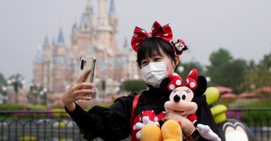 A visitor dressed as a Disney character takes a selfie while wearing a protective face mask at Shanghai Disney Resort as the Shanghai Disneyland theme park reopens following a shutdown due to the coronavirus outbreak, in Shanghai, China, May 11, 2020. (Reuters Photo)