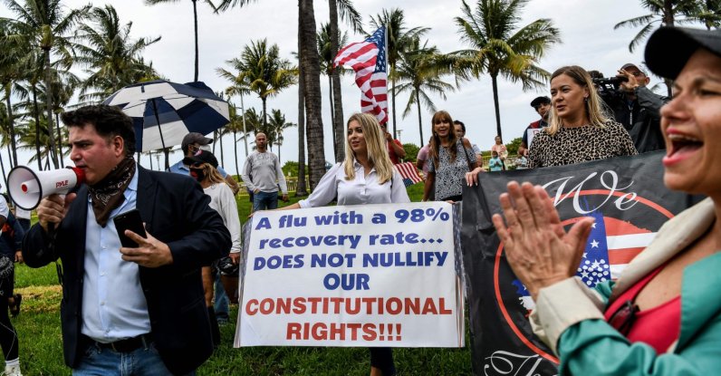 Protestors hold placards, wave the American flag and shout slogans as they participate in a "Freedom Rally" protest in support of reopening Florida, South Beach, Miami, May 10, 2020. (AFP Photo)