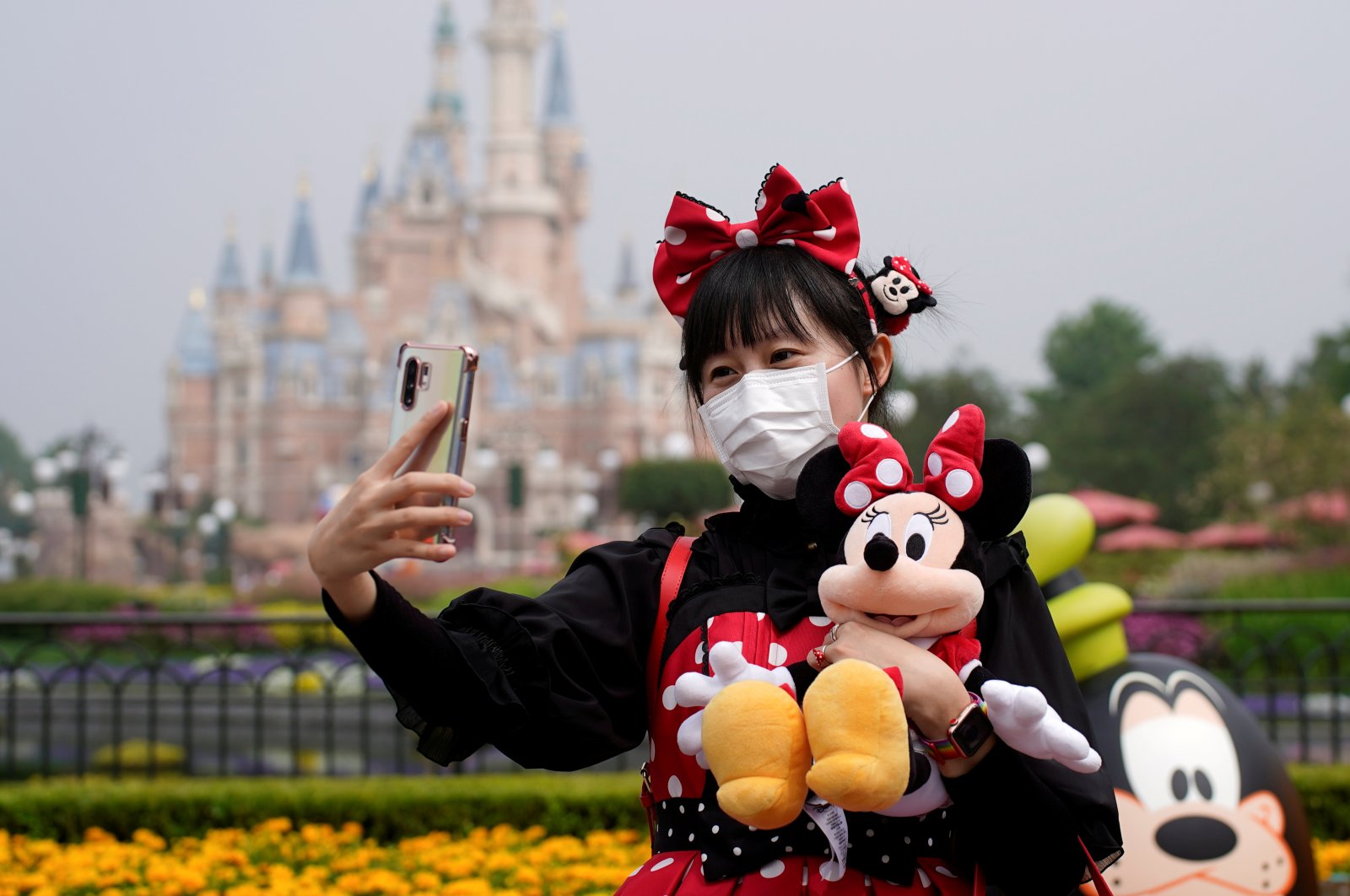 A visitor dressed as a Disney character takes a selfie while wearing a protective face mask at Shanghai Disney Resort as the Shanghai Disneyland theme park reopens following a shutdown due to the coronavirus outbreak, in Shanghai, China, May 11, 2020. (Reuters Photo)