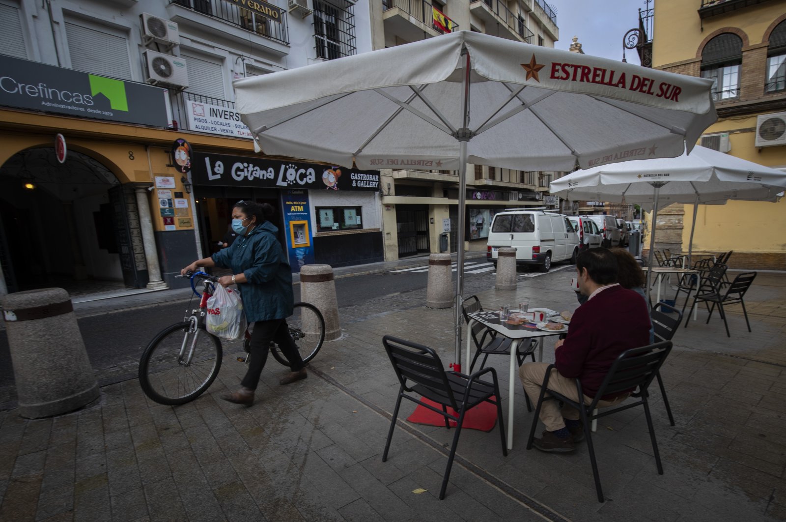Two people eat breakfast in a terrace bar, Seville, Spain, May 11, 2020. (AP Photo)