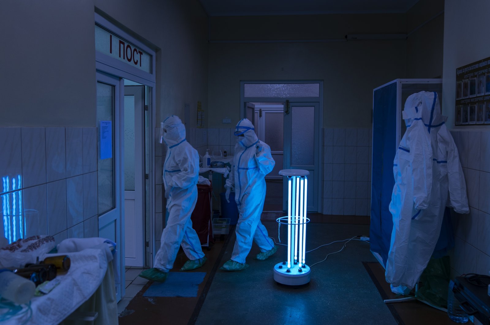 Medical specialists wearing special suits to protect against the coronavirus walk through a disinfectant corridor toward the intensive care unit at a regional hospital in Chernivtsi, Ukraine, May 4, 2020. (AP Photo)