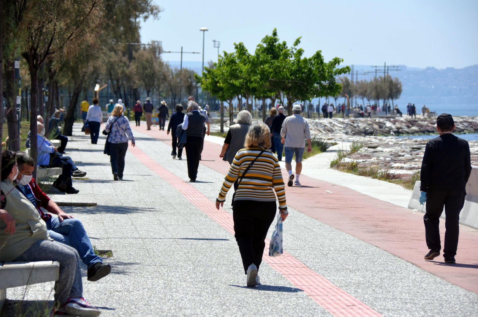 Senior citizens go for a stroll in Izmir's Karşıyaka after the curfew was temporarily lifted, May 10, 2020 (DHA Photo)