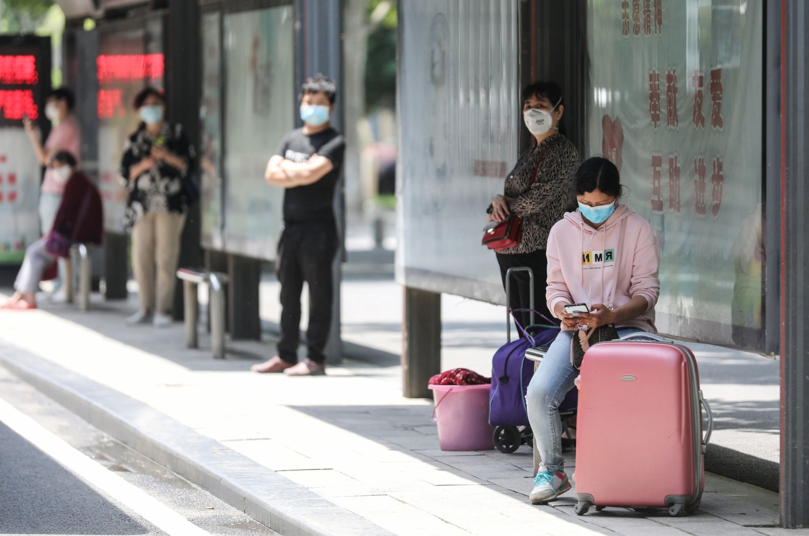 People wait at a bus station in Wuhan in China's central Hubei province on May 11, 2020. (AFP Photo)