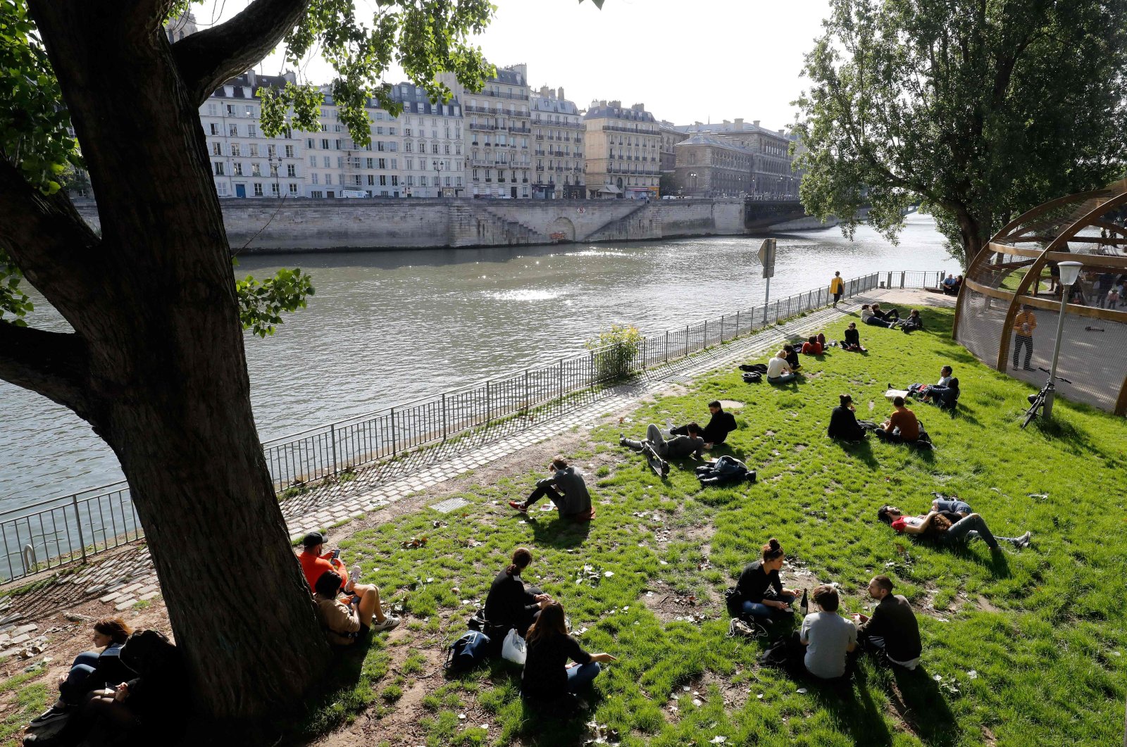 People gather along banks of the Seine river in Paris, on May 11, 2020, on the first day of France's easing of lockdown measures in place for 55 days to curb the spread of the COVID-19 pandemic, caused by the novel coronavirus. (AFP Photo)
