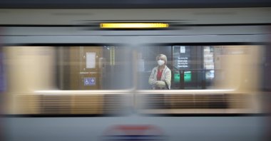 A passenger wearing a protective face mask and gloves waits for a train at Westminster Underground station, following the outbreak of the coronavirus disease London, Britain, May 12, 2020. (Reuters Photo)