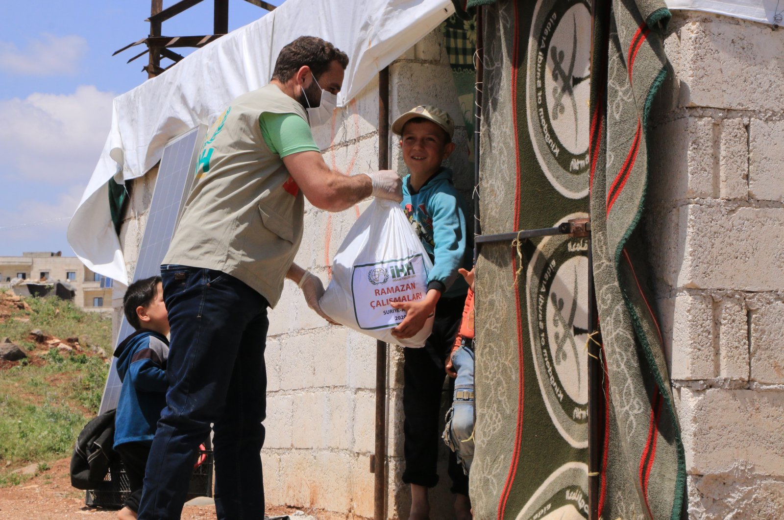 A İHH worker distributes aid to families in northwestern Syria’s Afrin, May 12, 2020. (AA Photo)