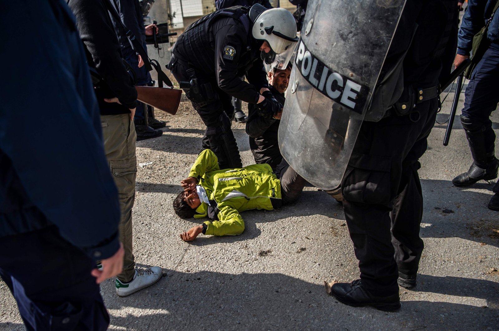Riot police detain a migrant during clashes near the Moria camp for refugees and migrants, on the island of Lesbos, Greece, March 2, 2020. (AFP Photo)