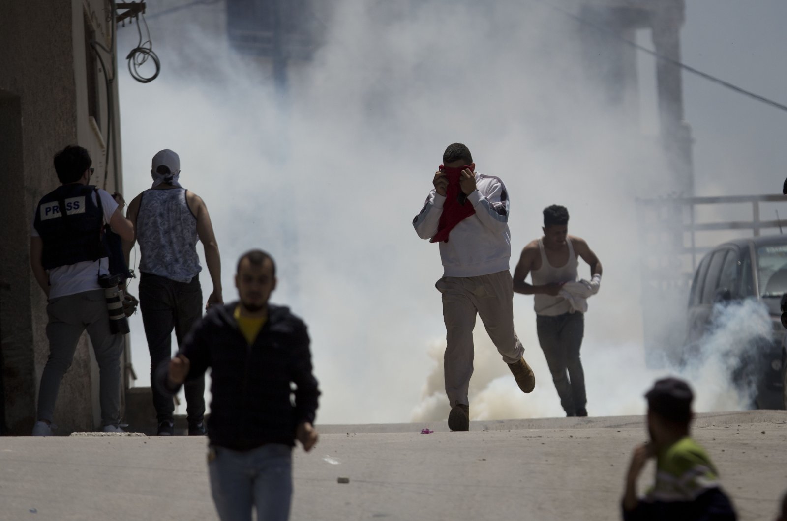 Palestinians run away from tear gas fired by Israeli soldiers in the village of Yabad near the West Bank city of Jenin, May. 12, 2020. (AP Photo)