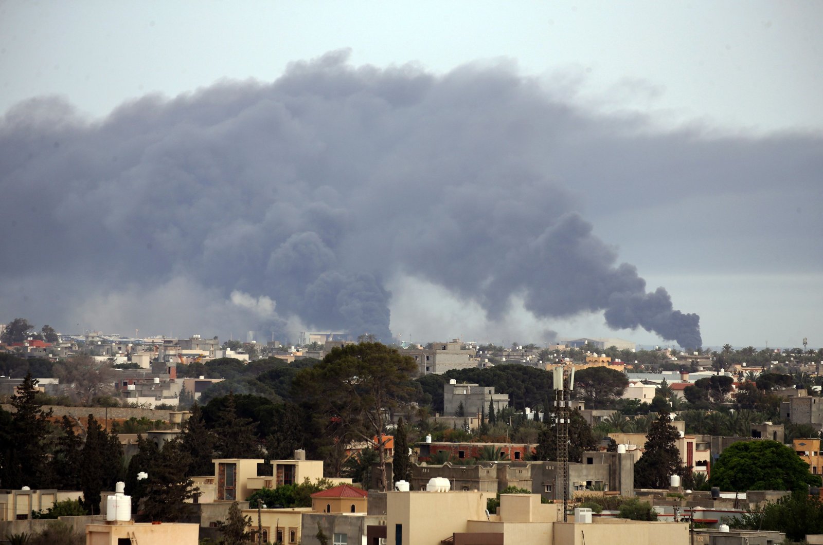 Smoke fumes rise above buildings in the Libyan capital Tripoli, during reported shelling by Khalifa Haftar's forces, on May 9, 2020. (AFP Photo)