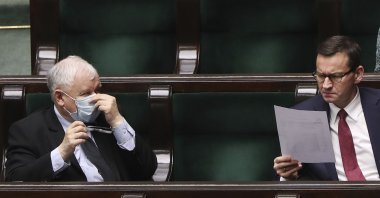Poland's main ruling party leader Jaroslaw Kaczynski, left, wearing a mask for protection against the coronavirus and Polish Prime Minister Mateusz Morawiecki, right, work in parliament on new legislation that is to ensure the health and safety of the postponed presidential election to be held this summer, in Warsaw, Poland, Tuesday, May 12, 2020. (AP Photo)