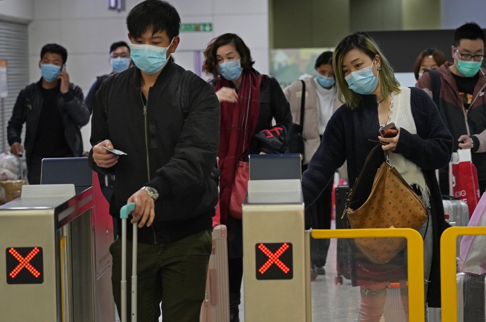 Passengers wearing protective face masks arrive at a high speed train station in Hong Kong, Jan. 28, 2020. (AP Photo)