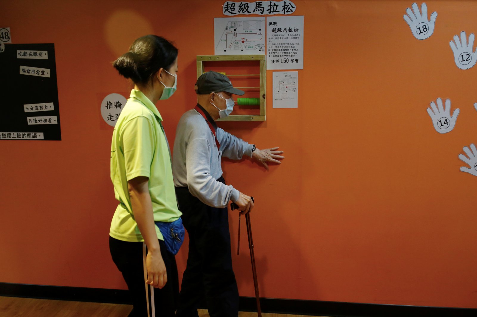 A senior wears a mask to protect himself from coronavirus disease (COVID-19) while walking along a wall at an elderly day care center in Taipei, Taiwan May 8, 2020. Picture taken May 8, 2020. (Reuters Photo)