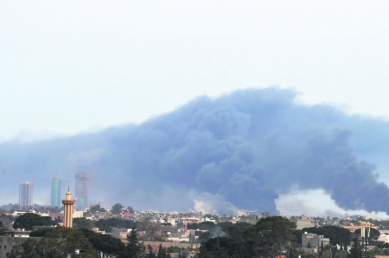Smoke fumes rise above buildings in the Libyan capital Tripoli, during reported shelling by renegade commander Haftar's forces, on May 9, 2020 (AFP Photo)