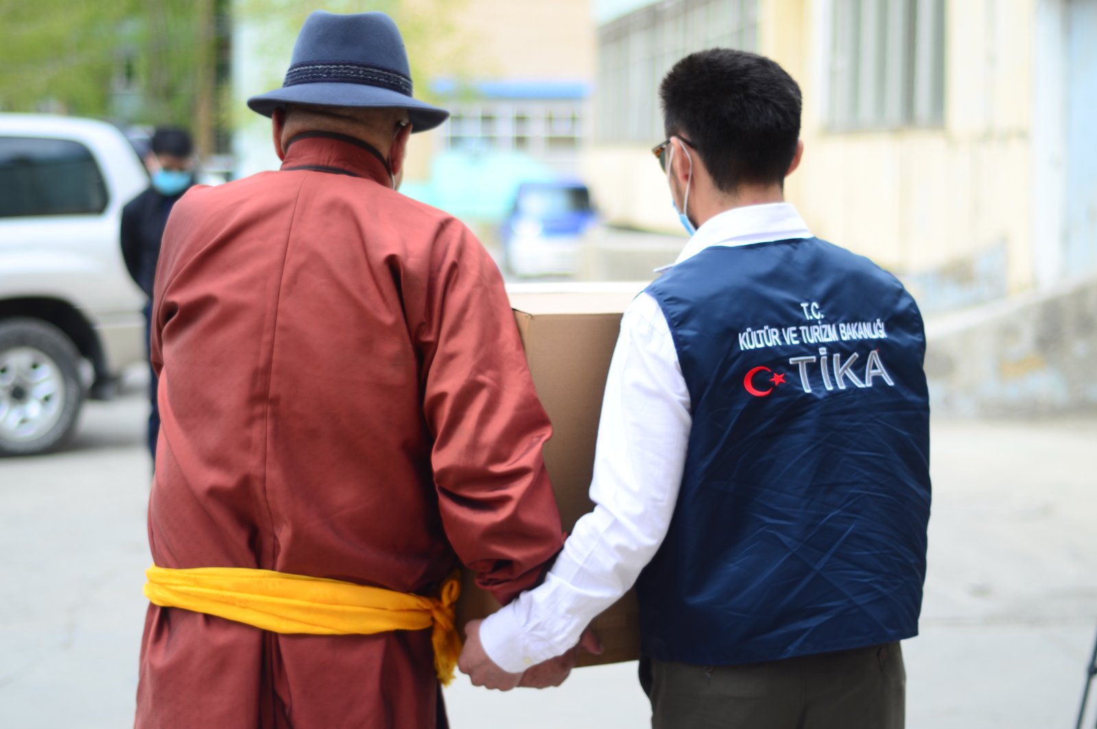 A TIKA volunteer helps a man carry an aid box in Ulaanbaatar, Mongolia, May 12, 2020. (AA Photo)