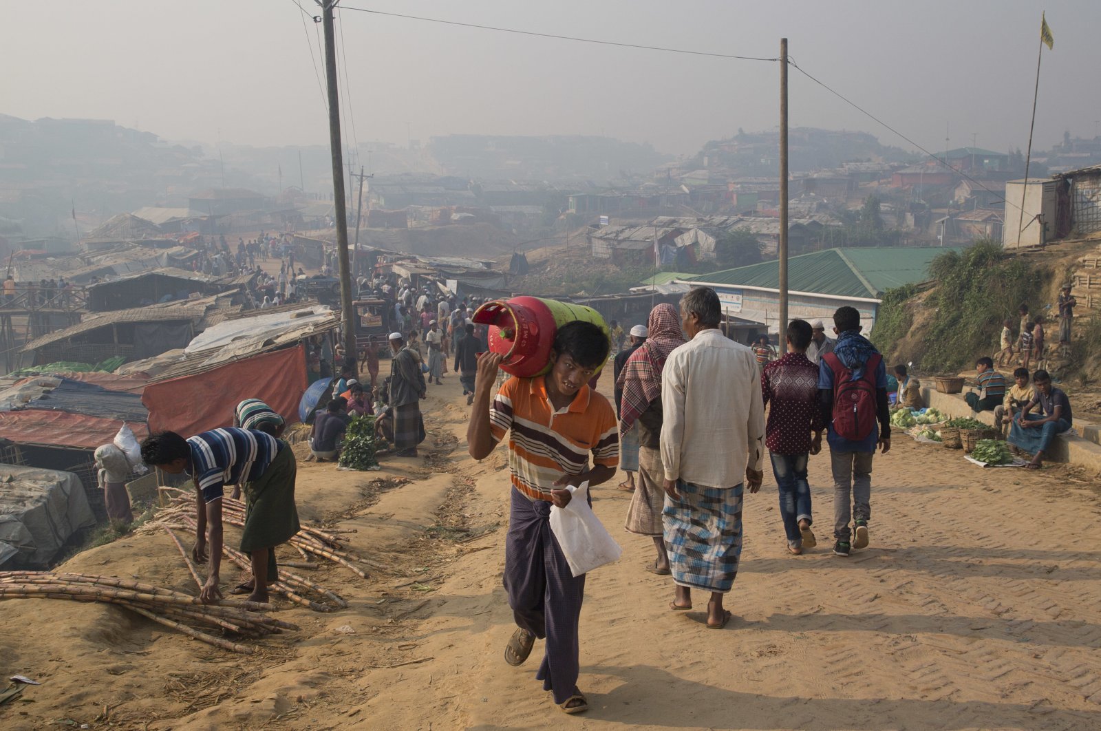 A Rohingya refugee walks carrying a cooking gas cylinder inside Balukhali refugee camp near Cox's Bazaar, Nov. 17, 2018. (AP Photo)