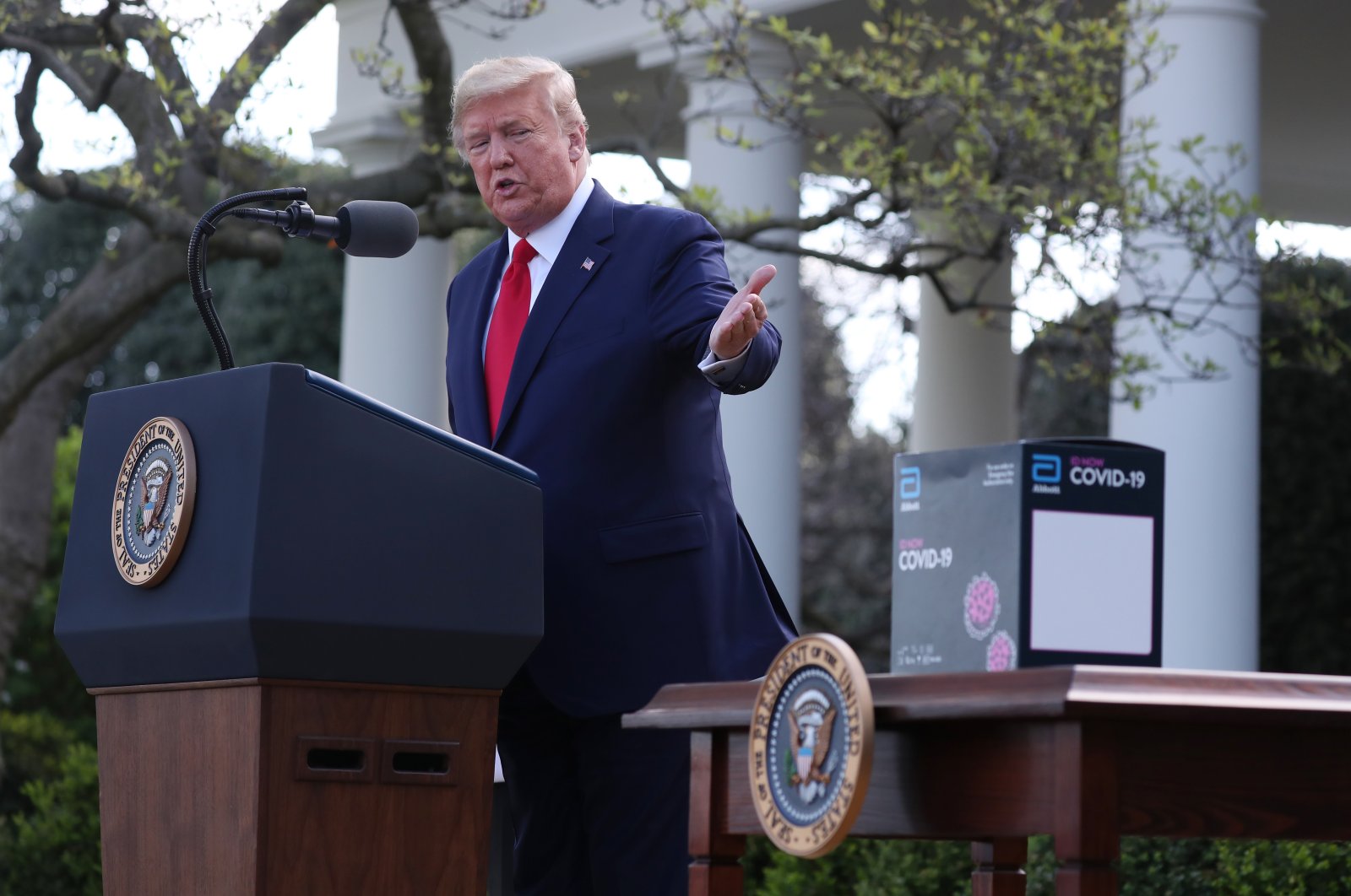 US President Donald Trump gestures towards the Abbot ID NOW COVID-19 test box during the Coronavirus Task Force press briefing on the coronavirus in the Rose Garden at the White House, Washington, D.C., March 30, 2020. (EPA Photo)