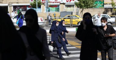 Iranians wear protective face masks and gloves, following the outbreak of the coronavirus disease (COVID-19), as they walk in Vali-E-Asr street, in Tehran, Iran, May 12, 2020. (Reuters Photo)