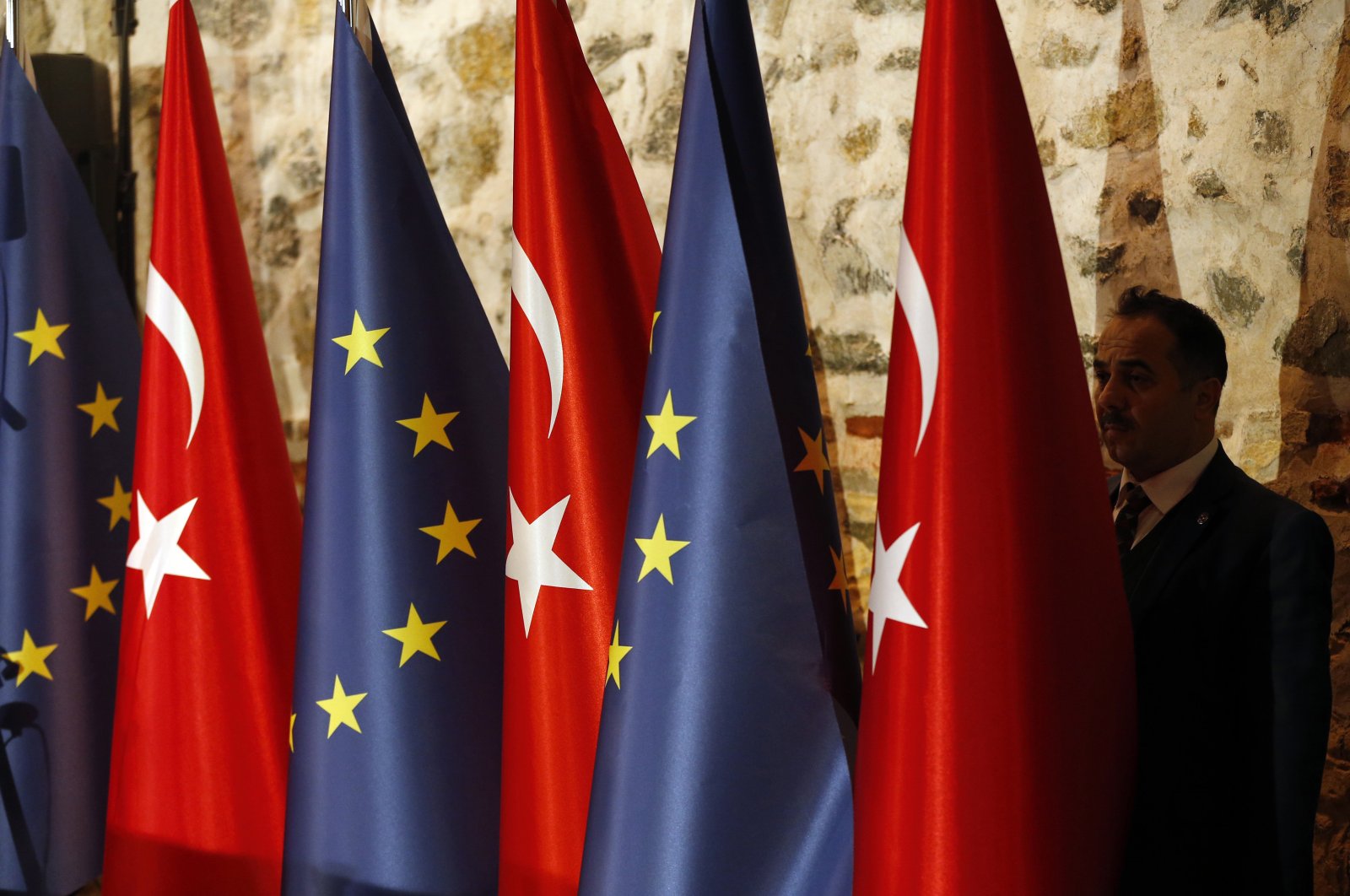 An official adjusts Turkey's and European Union's flags prior to the opening session of a high-level meeting in Istanbul, Feb. 28, 2019. (AP Photo)