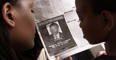 This June 12, 2002, file photo shows readers look at a newspaper carrying the photograph of Rwandan Felicien Kabuga wanted by the United States, in Nairobi, Kenya. (Reuters Photo)