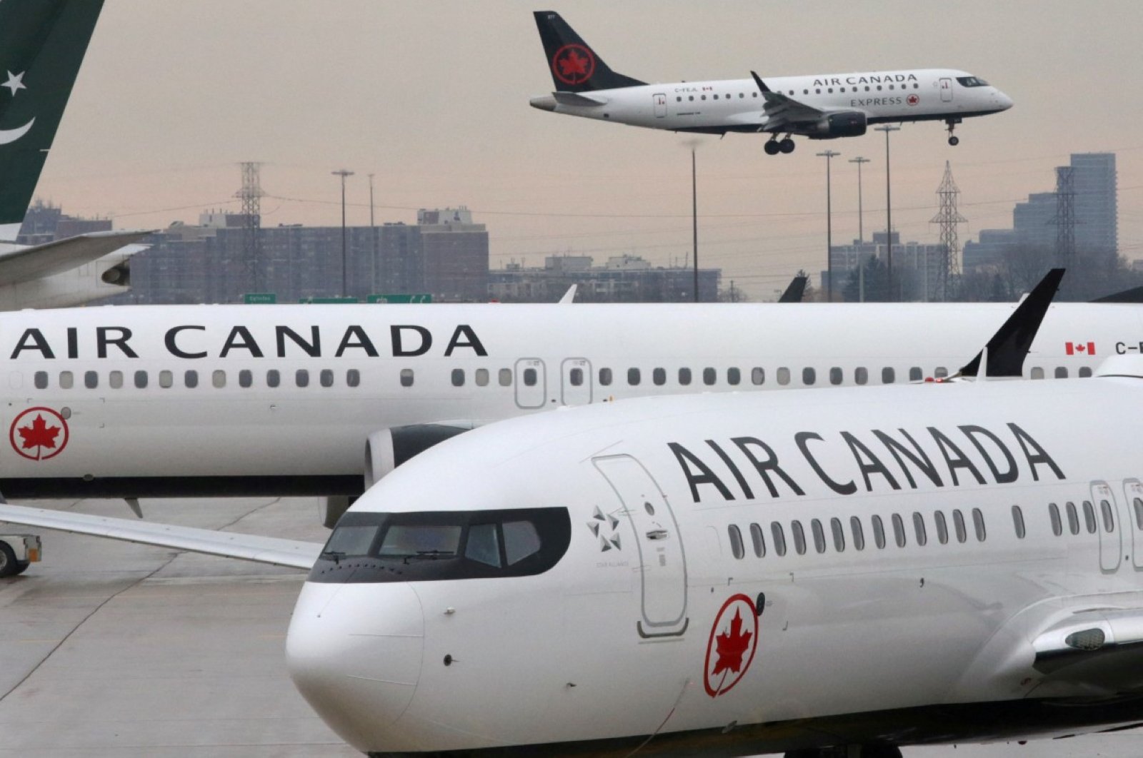Two Air Canada Boeing 737 MAX 8 aircrafts are seen on the ground as Air Canada Embraer aircraft flies in the background at Toronto Pearson International Airport in Toronto, Ontario, Canada, March 13, 2019. (REUTERS Photo)