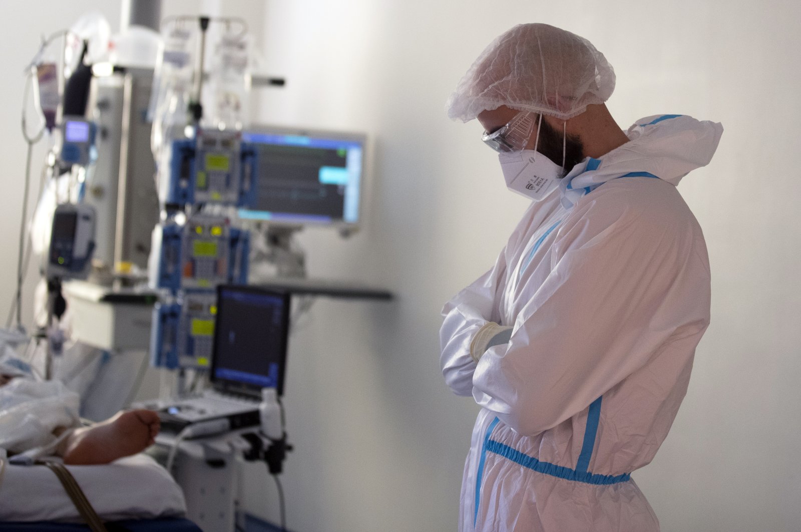 A healthcare worker looks down while they assist a COVID-19 patient at one of the intensive care units (ICU) of the Ramon y Cajal hospital in Madrid, Spain, Spain, Friday, April 24, 2020. (AP Photo)