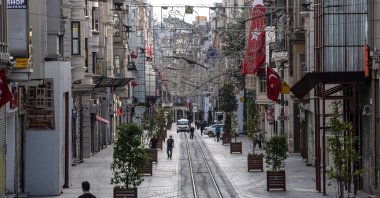 People walk in the deserted İstiklal street at Taksim district in Istanbul on May 16, 2020, during a four-day curfew to prevent the spread of the pandemic COVID-19 caused by the novel coronavirus. (AFP Photo)