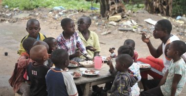 Children orphaned in attacks by rebel groups eat under a tree after being taken in by a local woman, in eastern Democratic Republic of Congo, June 4, 2018. (AP Photo)