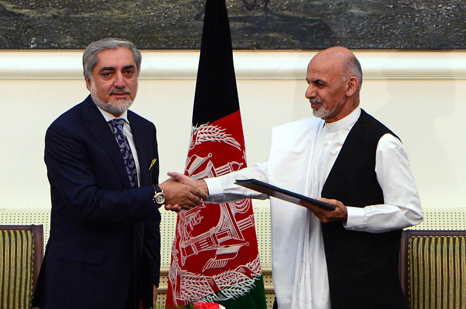 In this file photo, Afghan presidential candidates Abdullah Abdullah (L) and Ashraf Ghani Ahmadzai shake hands after signing a power-sharing agreement at the Presidential Palace in Kabul on Sept. 21, 2014. (AFP Photo)