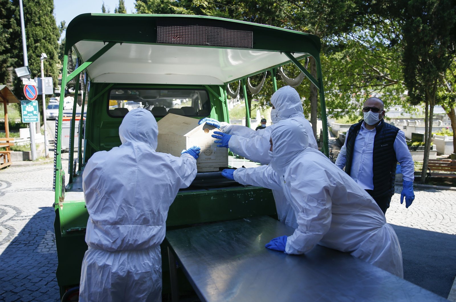 Morgue technicians wearing protective suits load the coffin of a woman who died of COVID-19 onto a hearse, Istanbul, Turkey, May 10, 2020. (AP Photo)