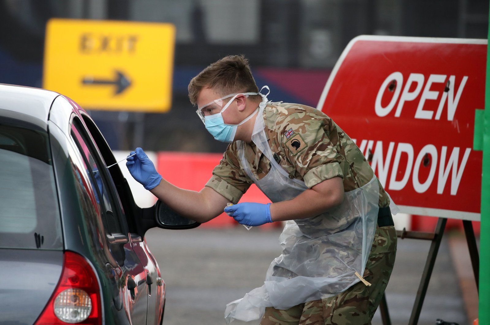 A soldier from 2 Scots Royal Regiment of Scotland tests a key worker for the coronavirus at a drive-in testing center at Glasgow Airport, U.K., April 29, 2020. (AFP Photo)