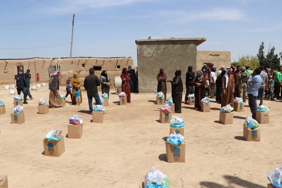 Syrians wait in line for aid packages provided by a Turkish humanitarian agency, Tal Abyad, May 18, 2020. (AA)