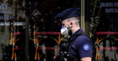 A French police officer wearing a protective face mask against the coronavirus walks in Paris, France, April 22, 2020. (Photo by Alfred Yaghobzadeh/acabapress.com via Reuters)
