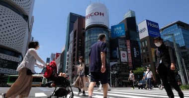 People wearing face masks amid concerns over the spread of the COVID-19 coronavirus cross a street in the Ginza shopping district in Tokyo, May 17, 2020. (AFP Photo)
