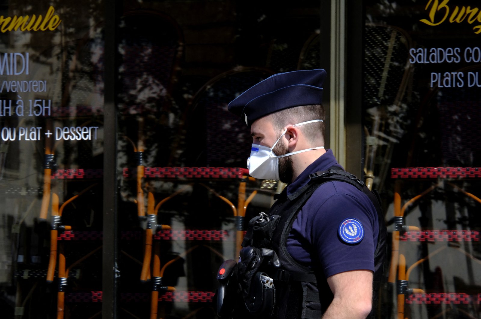 A French police officer wearing a protective face mask against the coronavirus walks in Paris, France, April 22, 2020. (Photo by Alfred Yaghobzadeh/acabapress.com via Reuters)