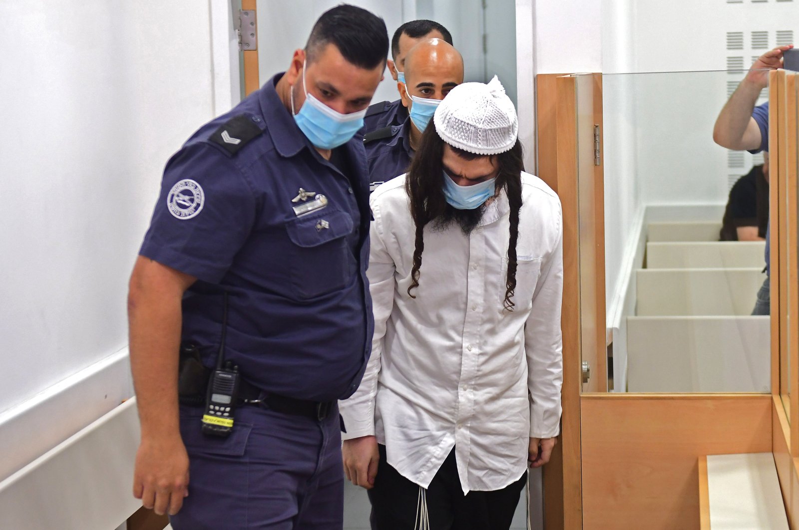 Amiram Ben-Uliel, a Jewish settler, is lead by police into court at the Central Lod District Court, in the central Israeli city on May 18, 2020, for his sentencing hearing over the 2015 arson attack that killed a Palestinian toddler and his parents. (AFP Photo)