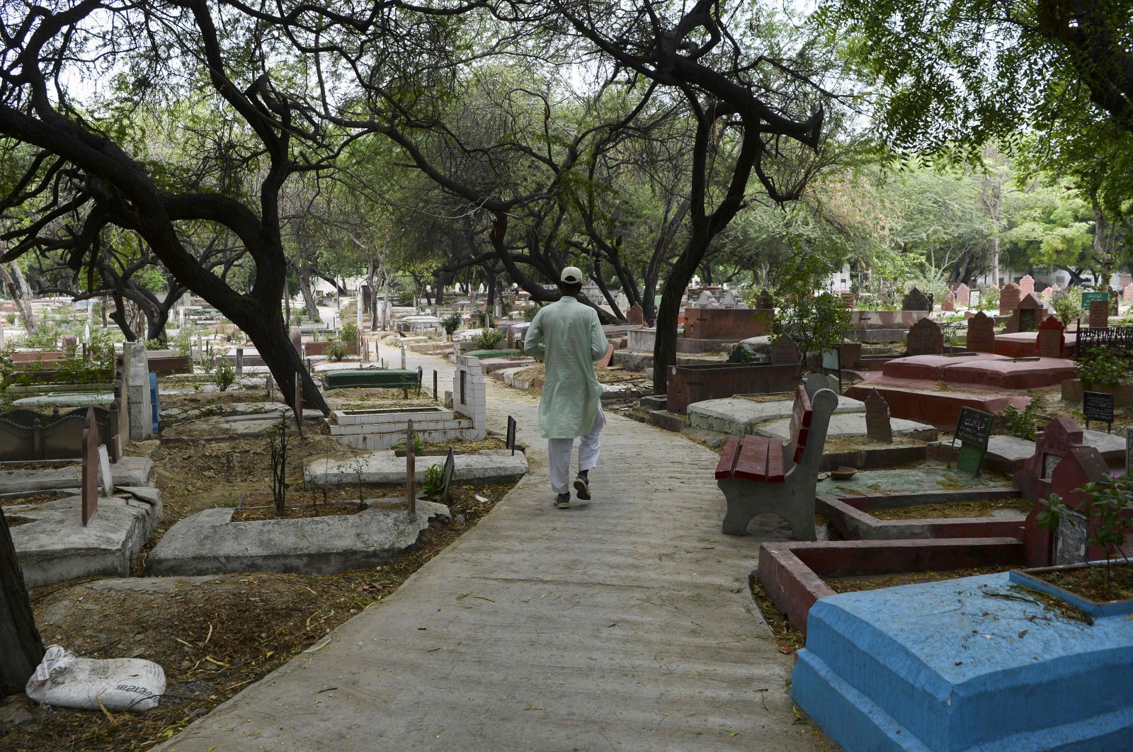 Gravedigger Mohammed Shamim walks back to his home after the burial of a COVID-19 victim in New Delhi, May 13, 2020. (AFP Photo)