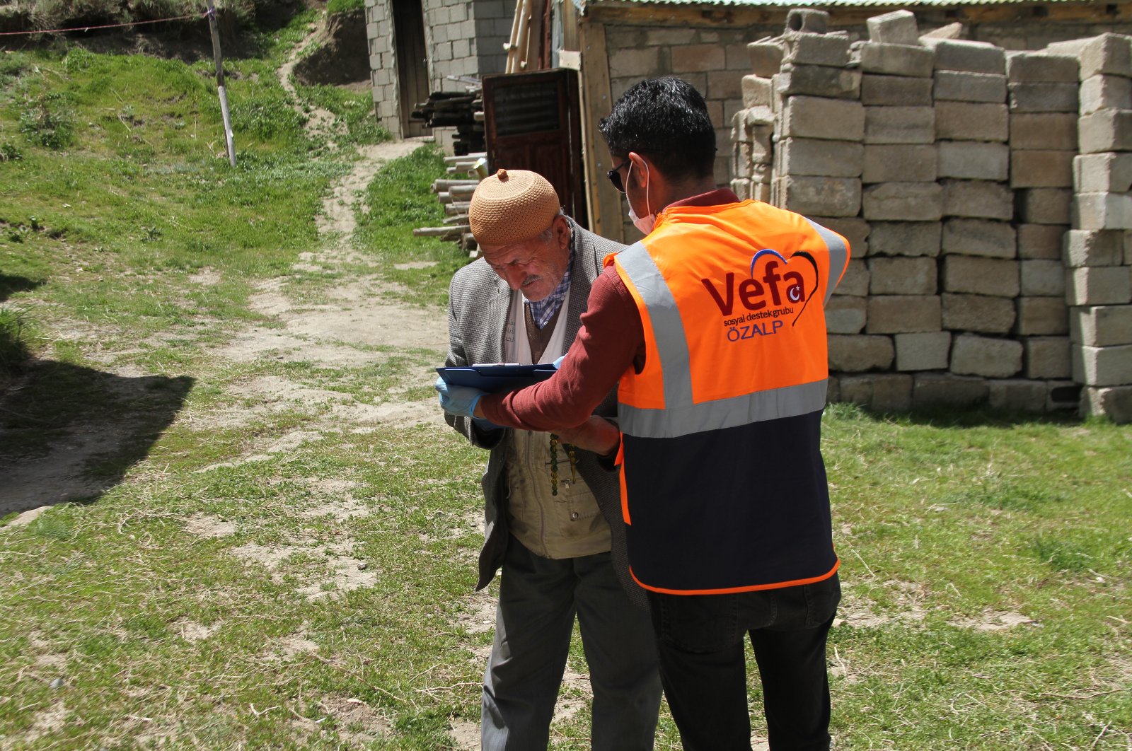 A Vefa Social Support Group volunteer distributes aid to an old man, Van, May 18, 2020. (AA)