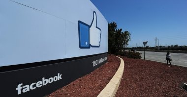 A woman shoots video of the sign at the entrance to the Facebook main campus in Menlo Park, California, U.S., May 15, 2012. (AFP Photo)