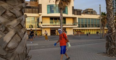 A man wears a diving mask as a protective face mask at the beachfront, Tel Aviv, Israel, May 16, 2020. (AP Photo)